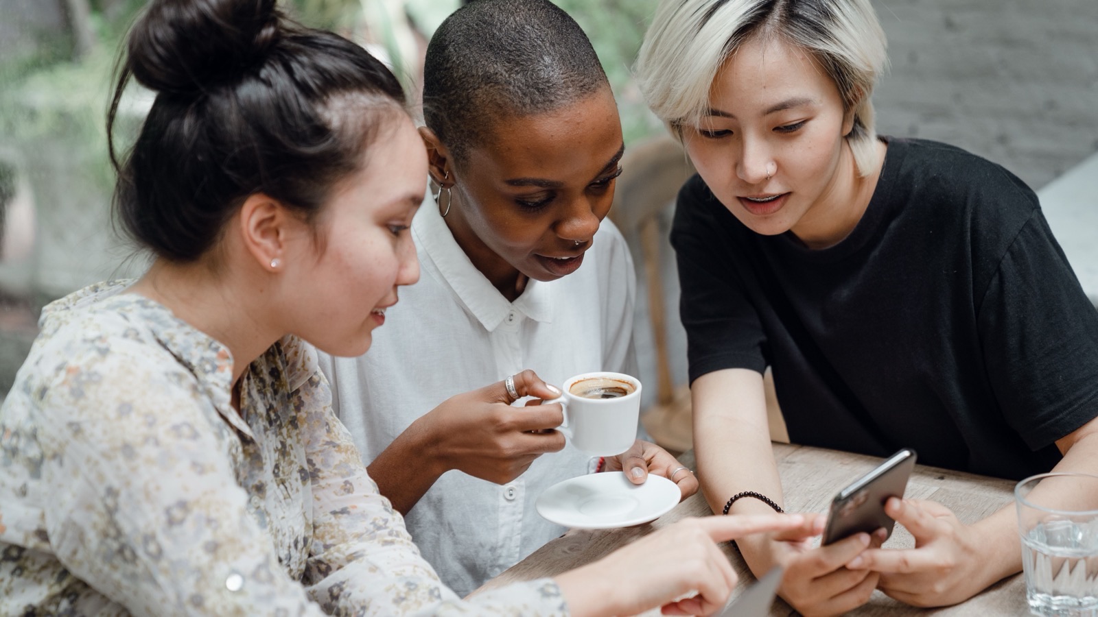 A friend group looking at trip ideas together on a phone.